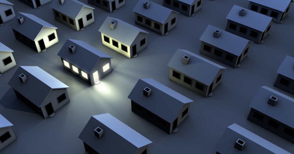 夜に街が停電し、一軒のみ灯りがついている画像